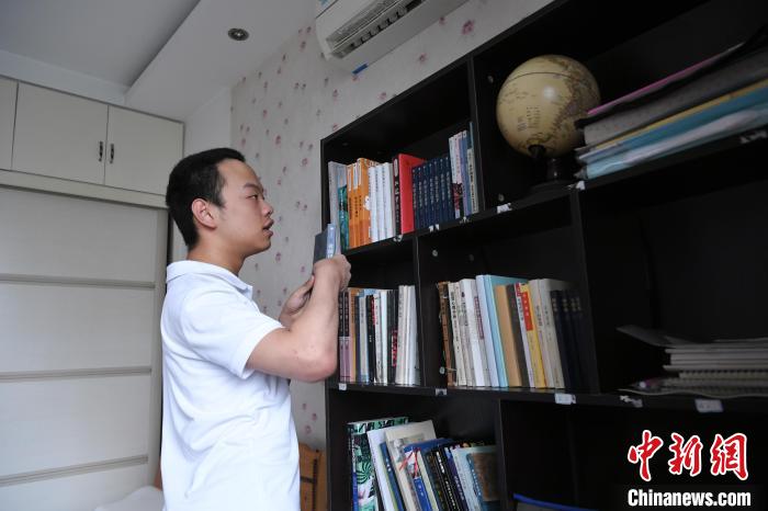 6月27日,汪艾韬在书架上翻阅书籍。 韩苏原 摄 6月27日,汪艾韬在书架上翻阅书籍。 韩苏原 摄