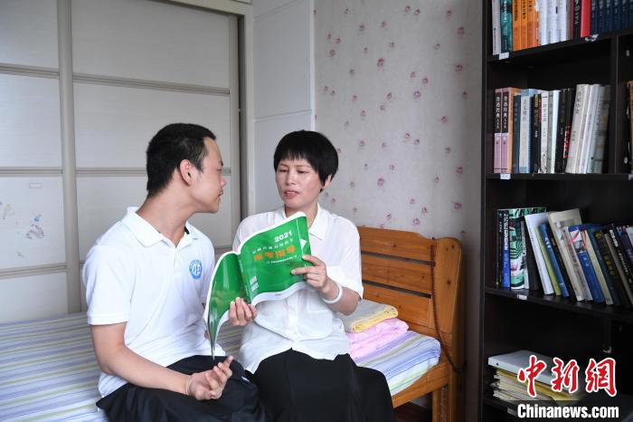 6月27日,汪艾韬和母亲一起在《2021安徽普通高校报考指导》书上用红笔勾出想去的学校。 韩苏原 摄 6月27日,汪艾韬和母亲一起在《2021安徽普通高校报考指导》书上用红笔勾出想去的学校。 韩苏原 摄