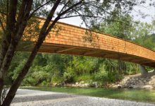 DANSArchitects的拱形木制人行天桥将斯洛文尼亚乡村与山脉相连